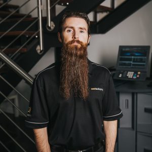 Bearded man in nexttechgroup uniform standing in office