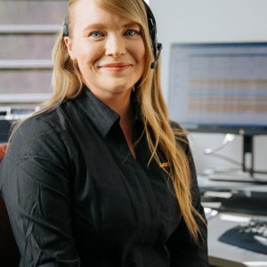 woman with blonde hair and phone headset smiling at camera